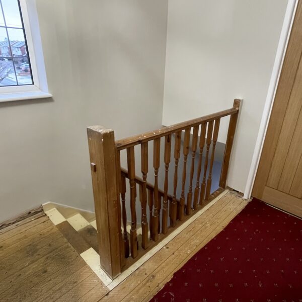 Staircase and landing renovation in Rugby featuring bespoke clad posts, increased handrail height, and toughened glass balustrade panels set into grooves. A modern and safer staircase transformation by Robert McVey Staircases.