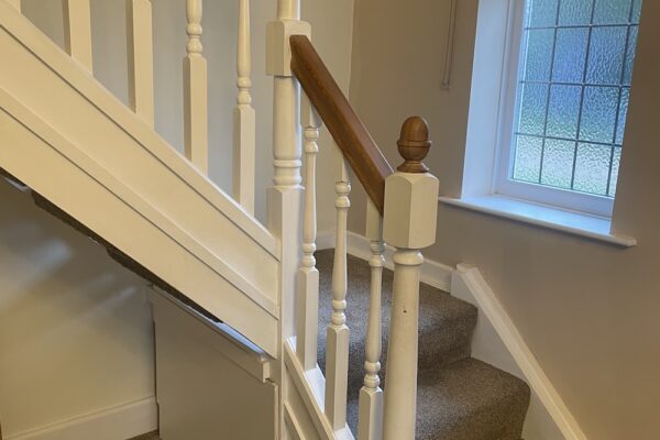Open tread staircase renovation in Burbage featuring bespoke oak newel posts, modern twist metal spindles, and custom under-stair doors. A stylish upgrade completed in just two days by Robert McVey Staircases.