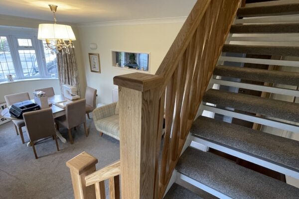 Open tread staircase renovation in Burbage featuring bespoke oak newel posts, modern twist metal spindles, and custom under-stair doors. A stylish upgrade completed in just two days by Robert McVey Staircases.