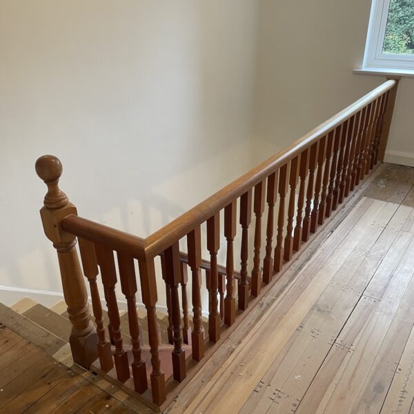 Staircase renovation in Broughton Astley featuring American white oak components with a clear oil finish and glass balustrade panels mounted on chrome brackets. A bright, modern hallway transformation completed in two days by Robert McVey Staircases.