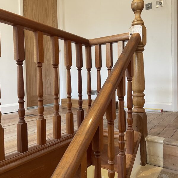 Staircase renovation in Broughton Astley featuring American white oak components with a clear oil finish and glass balustrade panels mounted on chrome brackets. A bright, modern hallway transformation completed in two days by Robert McVey Staircases.