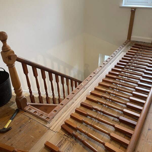 Staircase renovation in Broughton Astley featuring American white oak components with a clear oil finish and glass balustrade panels mounted on chrome brackets. A bright, modern hallway transformation completed in two days by Robert McVey Staircases.
