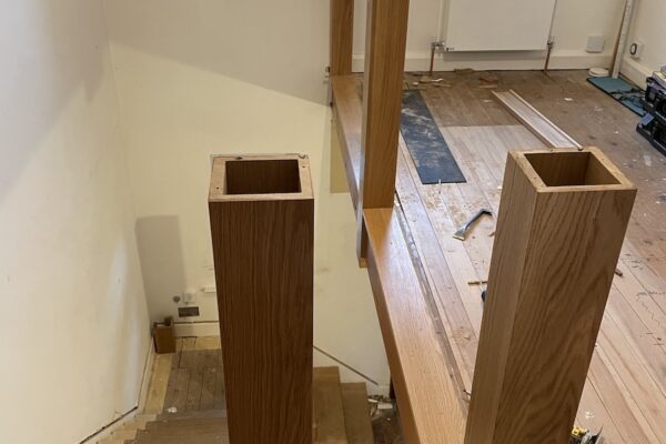 Staircase renovation in Broughton Astley featuring American white oak components with a clear oil finish and glass balustrade panels mounted on chrome brackets. A bright, modern hallway transformation completed in two days by Robert McVey Staircases.