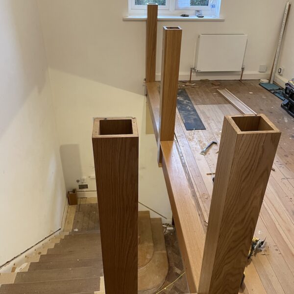 Staircase renovation in Broughton Astley featuring American white oak components with a clear oil finish and glass balustrade panels mounted on chrome brackets. A bright, modern hallway transformation completed in two days by Robert McVey Staircases.